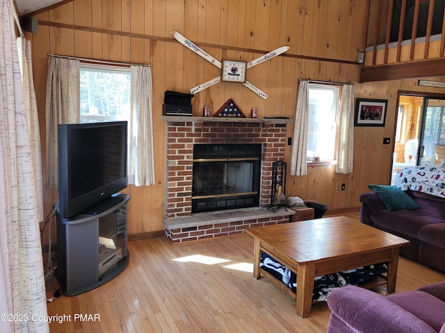 21 Cherry Ct, Clifton Township, PA 18424 - living room with light wood finished floors, a brick fireplace, wooden walls, baseboards, and high vaulted ceiling