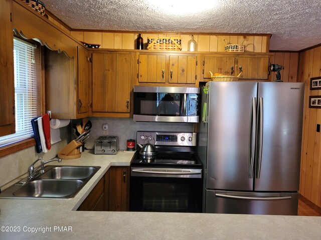21 Cherry Ct, Clifton Township, PA 18424 - kitchen with stainless steel appliances, a textured ceiling, a sink, light countertops, and brown cabinets