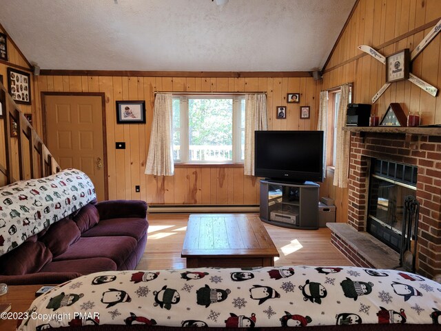 21 Cherry Ct, Clifton Township, PA 18424 - living area with lofted ceiling, light wood-style floors, wood walls, a brick fireplace, and a textured ceiling