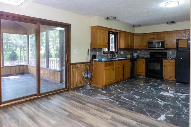 371 Ridge Cir, Cresco, PA 18326 - kitchen with stainless steel appliances, a textured ceiling, brown cabinetry, wooden walls, and wainscoting