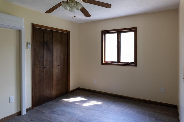 371 Ridge Cir, Cresco, PA 18326 - unfurnished bedroom featuring a wall mounted air conditioner, wood finished floors, a closet, and a ceiling fan