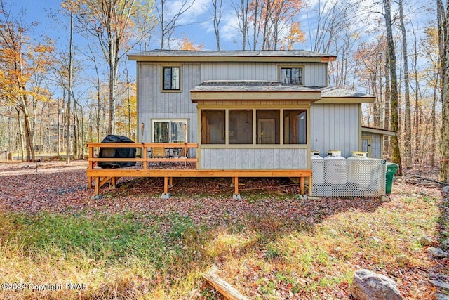 rear view of house with a deck and a sunroom