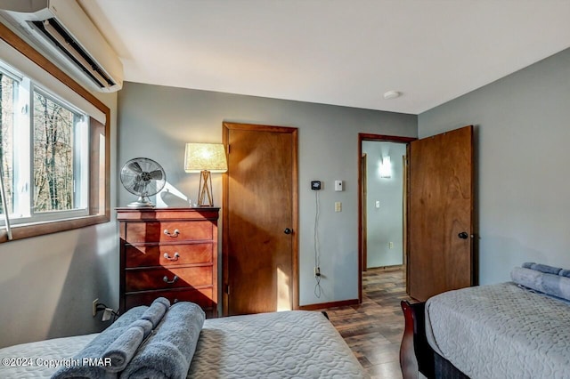 bedroom with a wall mounted air conditioner and wood finished floors