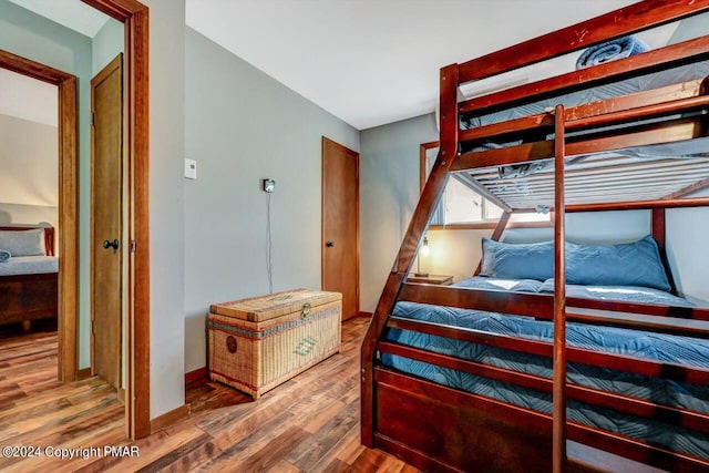 bedroom with wood finished floors and baseboards