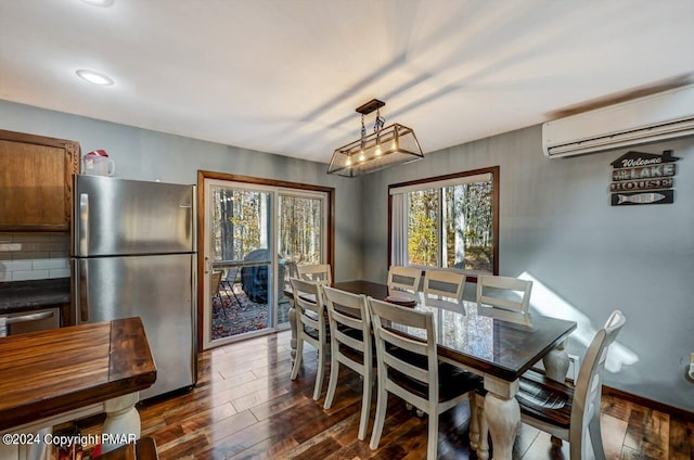 dining area with a wall unit AC, dark wood-type flooring, and a wealth of natural light