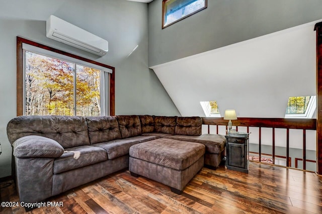 living area with lofted ceiling with skylight, a wall mounted air conditioner, and hardwood / wood-style floors