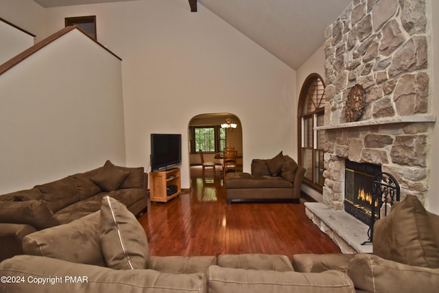 living room with a chandelier, a fireplace, wood finished floors, arched walkways, and high vaulted ceiling