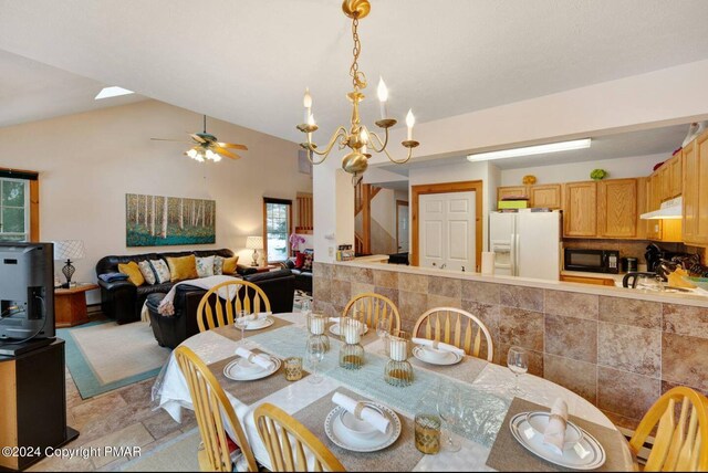 482 Spruce Dr, Tannersville, PA 18372 - dining area with lofted ceiling, stone finish floor, and ceiling fan with notable chandelier