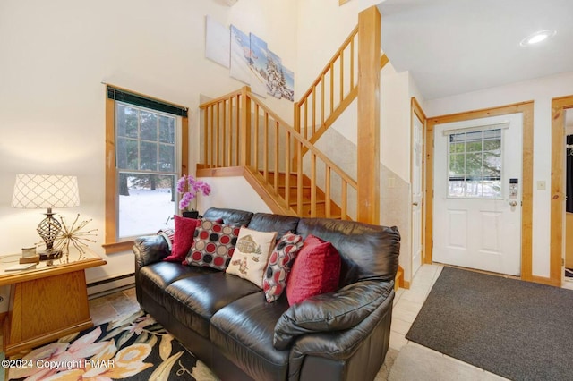 living area with a baseboard radiator and stairs