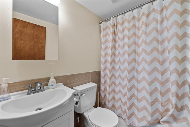 206 Maxatawny Dr, Pocono Lake, PA 18347 - full bathroom with vanity, toilet, a shower with shower curtain, a wainscoted wall, and tile walls
