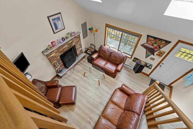 206 Maxatawny Dr, Pocono Lake, PA 18347 - living room featuring wood finished floors, vaulted ceiling, plenty of natural light, a baseboard radiator, and a fireplace