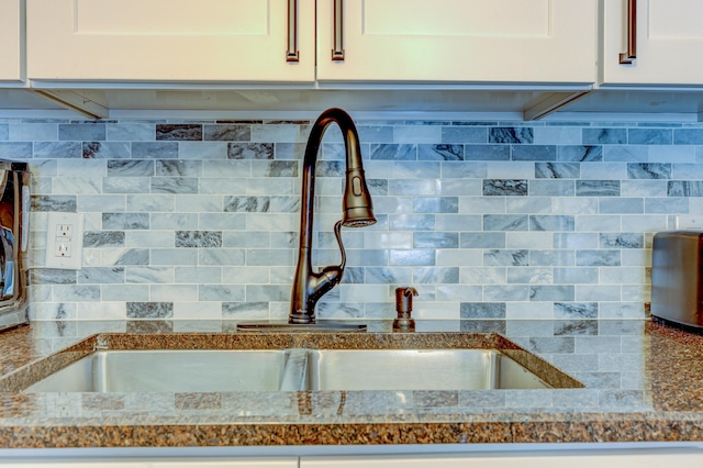 143 Cathleen Dr, East Stroudsburg, PA 18302 - kitchen view of a sink, backsplash, and white cabinets