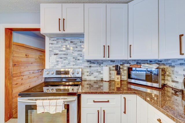 143 Cathleen Dr, East Stroudsburg, PA 18302 - kitchen featuring appliances with stainless steel finishes, tasteful backsplash, dark stone countertops, and white cabinetry