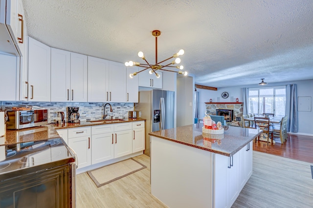 143 Cathleen Dr, East Stroudsburg, PA 18302 - kitchen featuring a sink, light wood-style flooring, a chandelier, a textured ceiling, and a center island