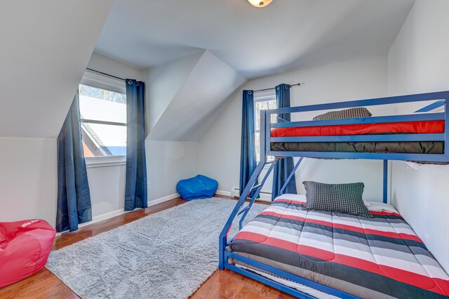 143 Cathleen Dr, East Stroudsburg, PA 18302 - bedroom with multiple windows, wood finished floors, vaulted ceiling, baseboards, and a baseboard heating unit