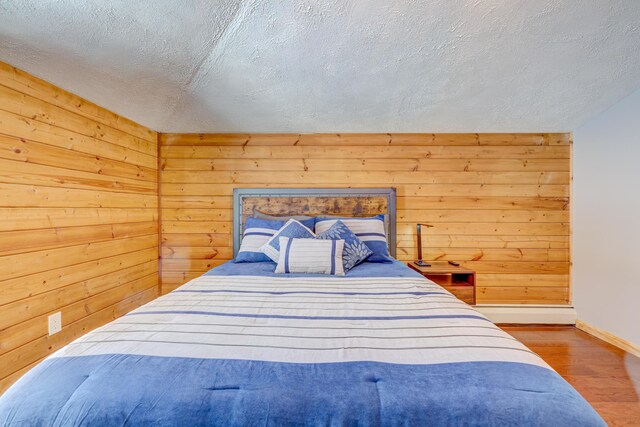 143 Cathleen Dr, East Stroudsburg, PA 18302 - bedroom with wood finished floors, baseboards, wooden walls, and a textured ceiling