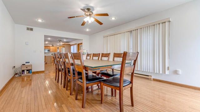 dining room with visible vents, light wood-style flooring, baseboards, and a ceiling fan