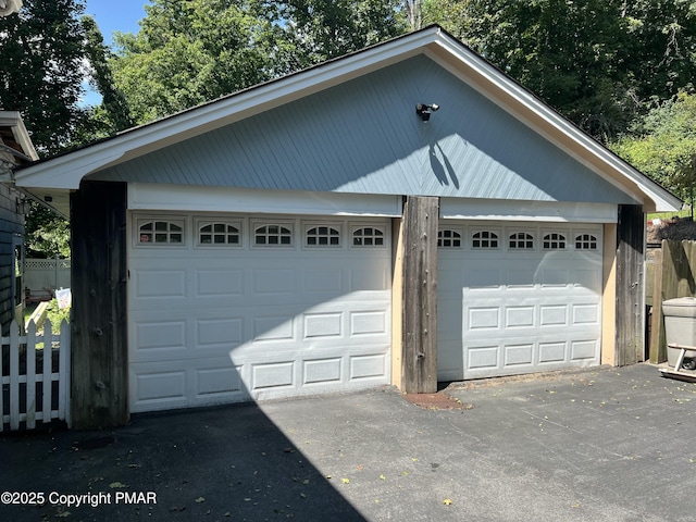 detached garage featuring fence