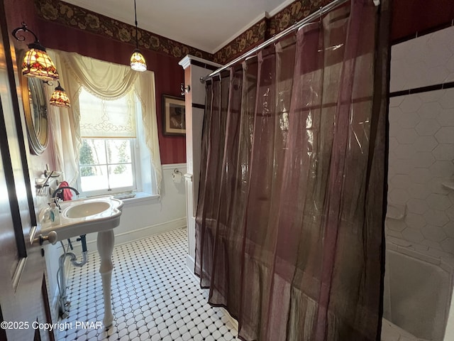 bathroom featuring baseboards, a sink, and a shower with curtain