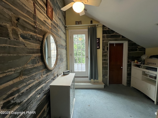 bathroom featuring lofted ceiling, visible vents, and wood walls