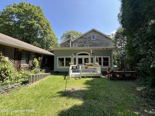 exterior space with french doors, a front lawn, a chimney, and a wooden deck