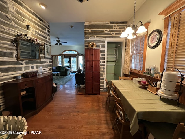 kitchen featuring ceiling fan with notable chandelier, dark wood finished floors, tile counters, and pendant lighting