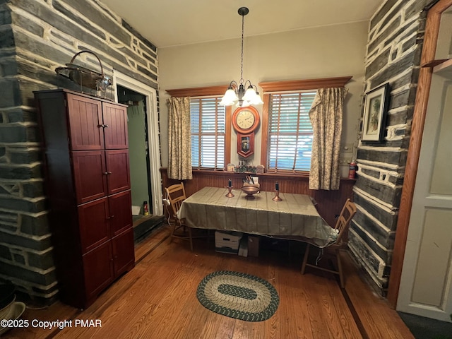 dining room with dark wood-style floors and a notable chandelier