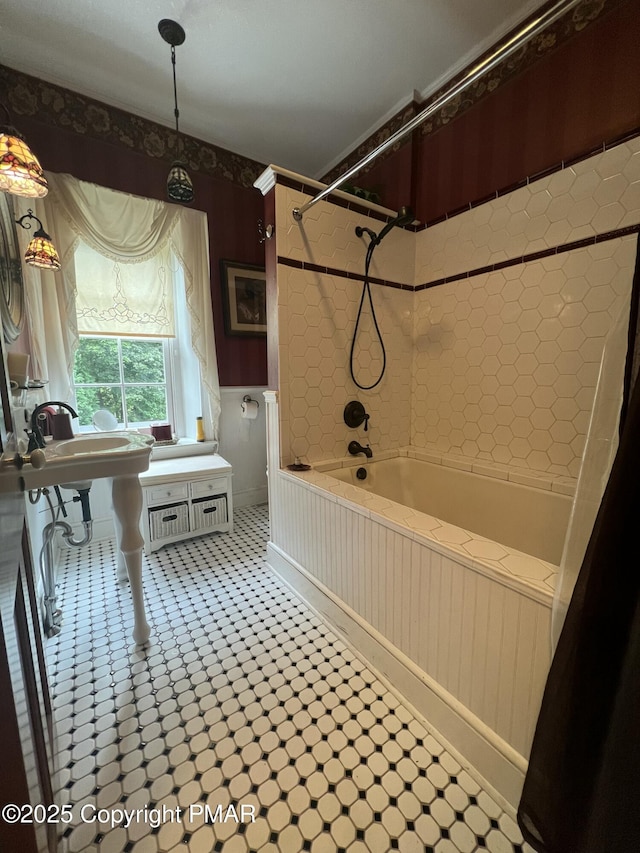 full bath with a wainscoted wall, bathtub / shower combination, and tile patterned floors