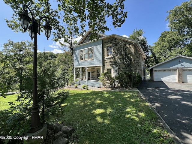 view of front of property featuring a porch, stone siding, a front lawn, and a garage