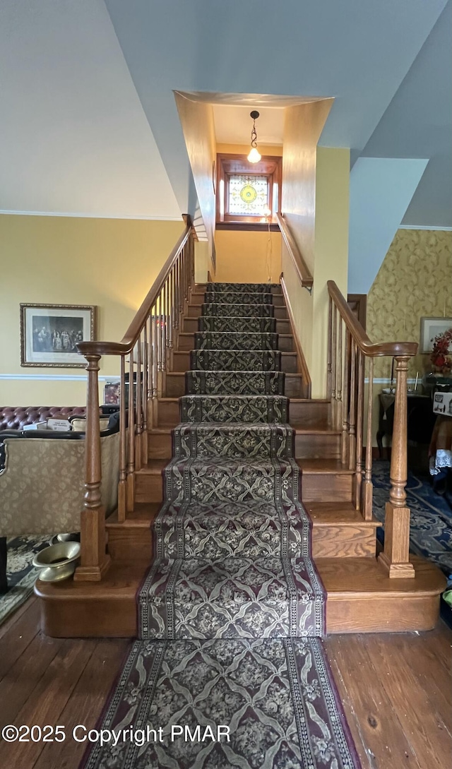 stairs with wallpapered walls and wood-type flooring