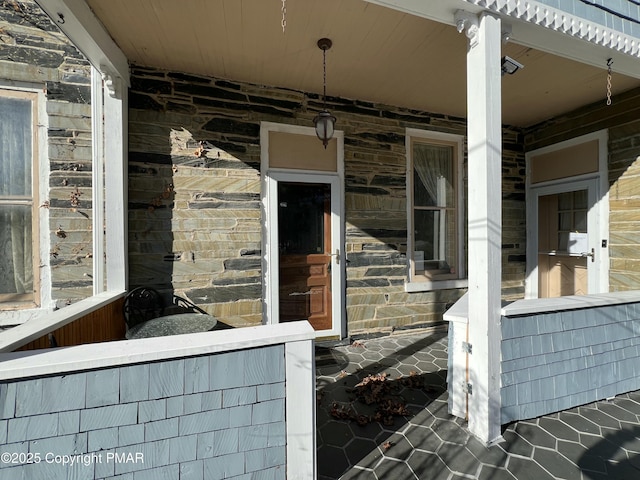 property entrance featuring stone siding and a porch