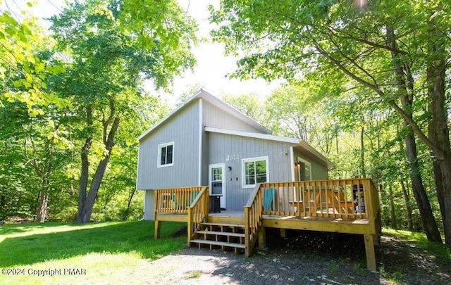 rear view of house featuring a yard and a deck