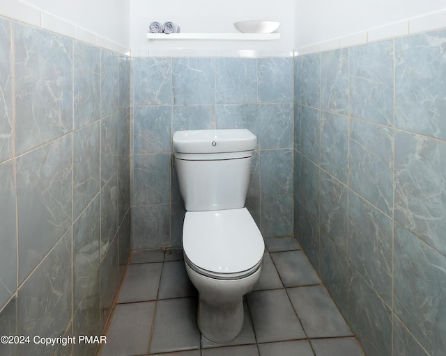 bathroom featuring toilet, tile walls, and tile patterned floors