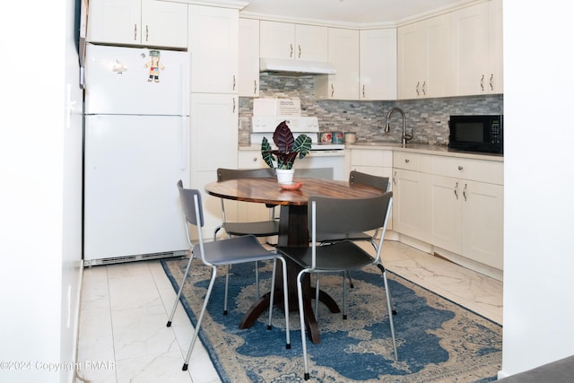 kitchen with white appliances, under cabinet range hood, marble finish floor, and a sink