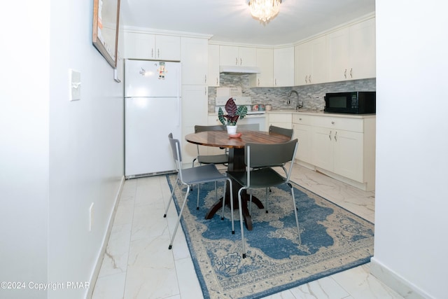 kitchen featuring white appliances, baseboards, decorative backsplash, marble finish floor, and white cabinetry