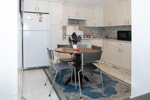 kitchen featuring marble finish floor, white appliances, backsplash, and under cabinet range hood