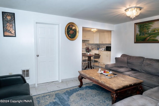 living area featuring a chandelier, marble finish floor, and visible vents