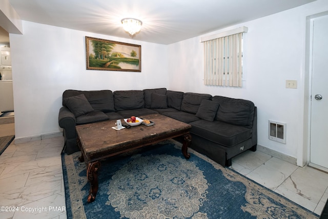 living area featuring marble finish floor, visible vents, baseboards, and stacked washing maching and dryer