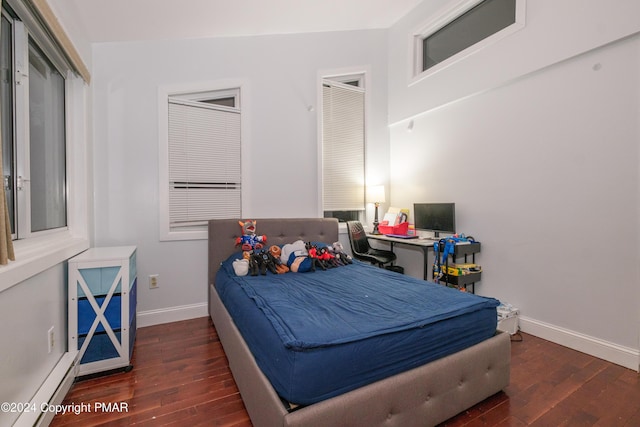 bedroom featuring baseboard heating, baseboards, and hardwood / wood-style floors