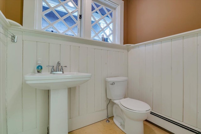 bathroom with a sink, toilet, a baseboard heating unit, and wainscoting