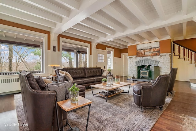 living area with stairway, beam ceiling, and wood finished floors