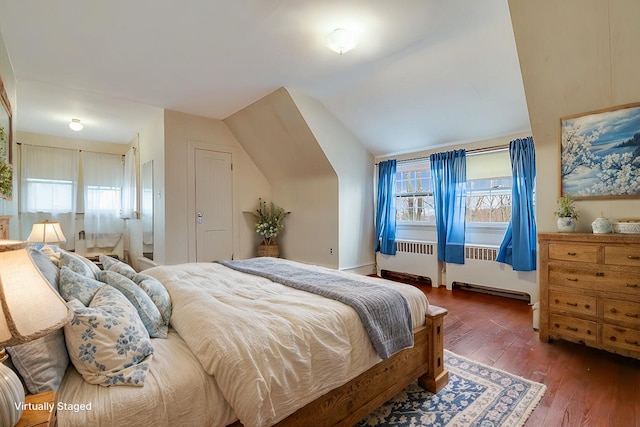 bedroom with radiator, lofted ceiling, and hardwood / wood-style flooring