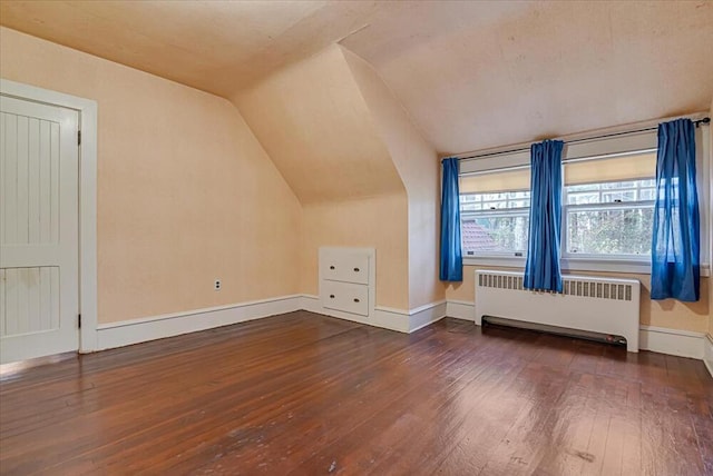 bonus room with hardwood / wood-style floors, radiator heating unit, baseboards, and lofted ceiling
