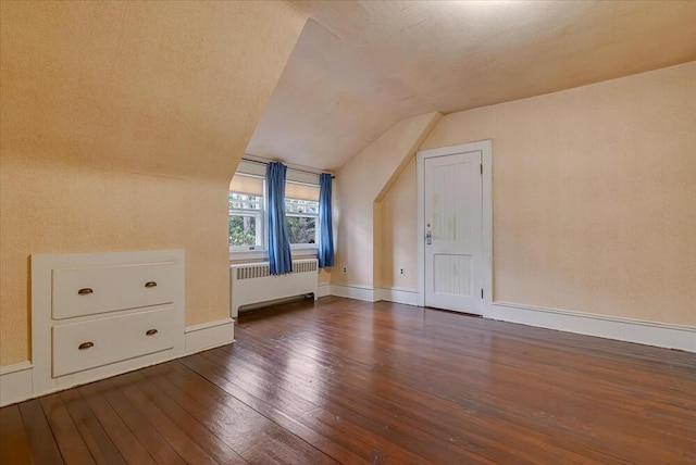 bonus room with radiator, baseboards, vaulted ceiling, and hardwood / wood-style flooring