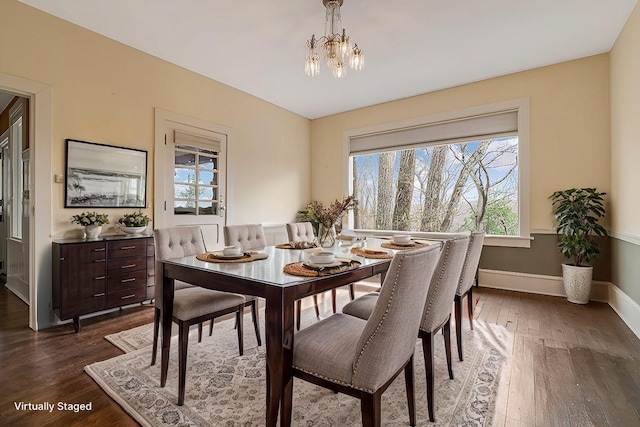 dining area with a notable chandelier, dark wood-style floors, and baseboards
