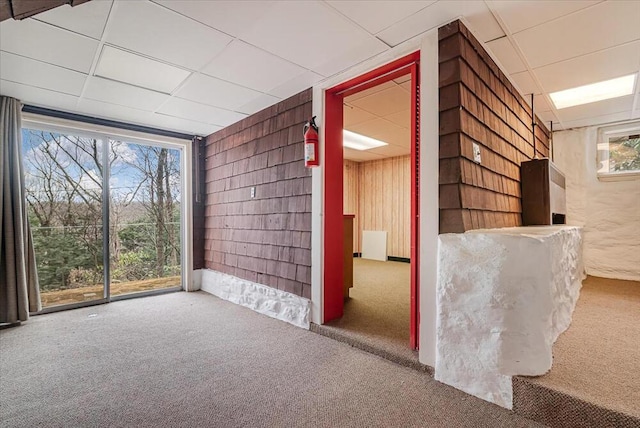 carpeted empty room with a drop ceiling