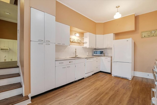 kitchen featuring open shelves, a sink, light countertops, light wood-type flooring, and white appliances