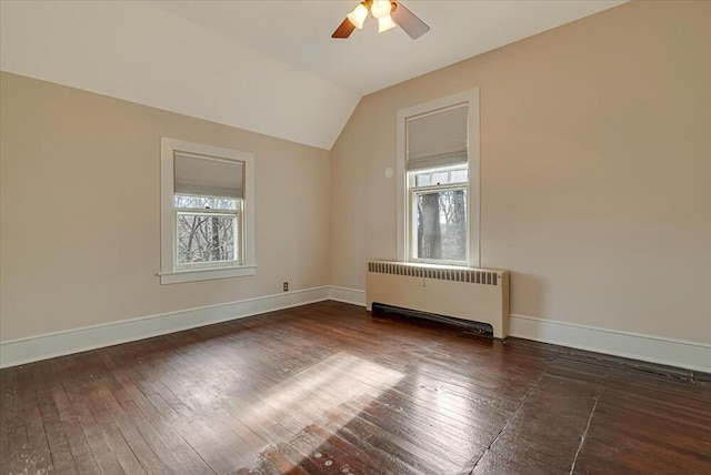 unfurnished room featuring radiator heating unit, plenty of natural light, hardwood / wood-style flooring, and a ceiling fan
