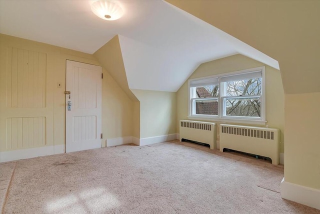 additional living space with radiator heating unit, lofted ceiling, and carpet floors