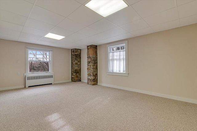 empty room featuring radiator, carpet, and plenty of natural light